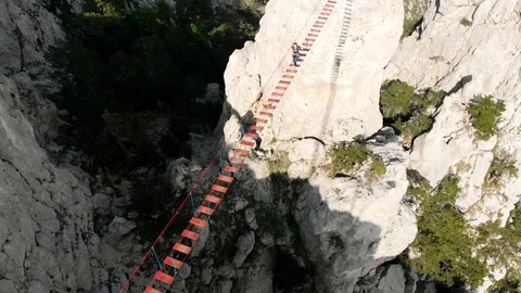 Person walking rope bridge, aerial view.... | Stock Video | Pond5