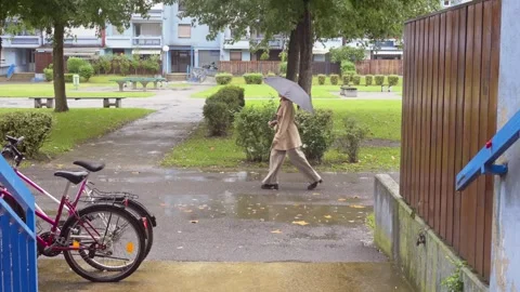 Person walking slow motion beige coat autumn red hair umbrella serious confident Stock Footage 284868463