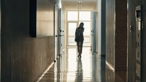 Person Walking Through Dimly Lit Office Lobby or Corridor Stock Footage 339639141