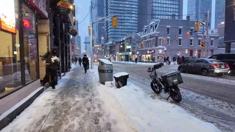 Person walking through heavy snowfall in downtown Stock Footage 327992730