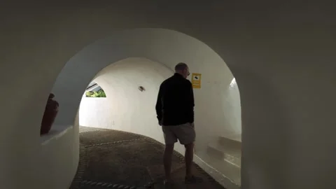 Person walking through Lagomar cave house tunnel in Lanzarote 動画素材 337799803