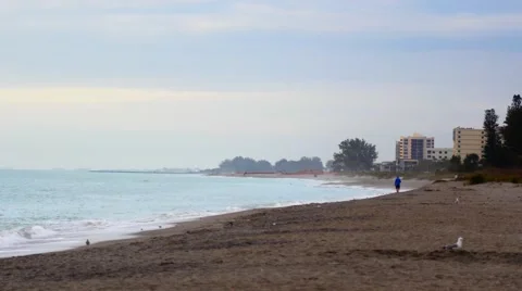 Person walks in distance on beautiful empty beach, 4K Stock Footage 47446758