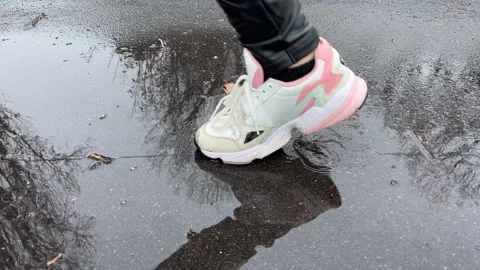 Person walks on the puddle on the asphalt Video stock 228725040