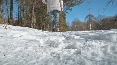 A person walks through snow while leaving footprints on a winter path. 库存影片 337101624