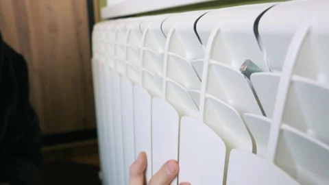 Person Warming Cold Hands On Central Heating Radiator In Room Stock Footage 329918968