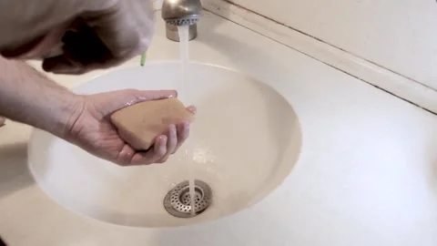 A person washes a plate with a sponge with detergent and rinses it with water Stock Footage 241111353