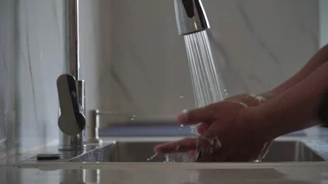 Person washing hands with soap under running water. 库存影片 336653593