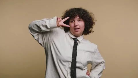 Person waves and makes fun gestures in front of a plain background during a.. 스톡 동영상 331990645