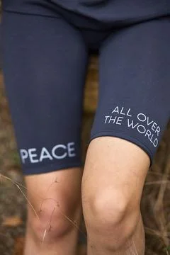 Person Wearing Peace Message Athletic Shorts Outdoors Amidst Nature Connect.. Stock Photos