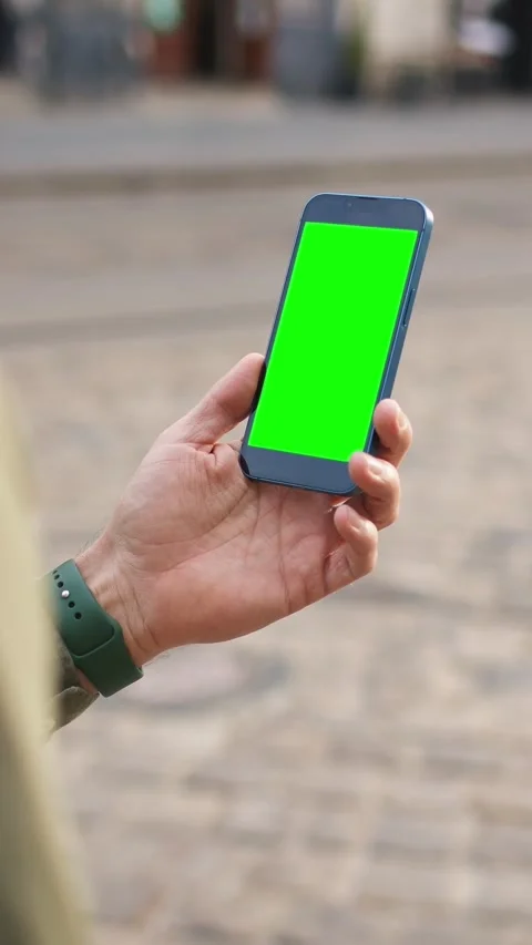 Person wearing smart watch while standing on paved street. Holding smartphone Stock Footage 314256031