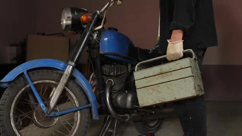 Person wearing work gloves and carrying an old style metal toolbox, ready to Stock Footage 342765948