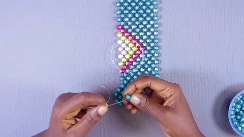 Person weaving colorful bead pattern. Threading and weaving jewelries Stock Footage 202153974