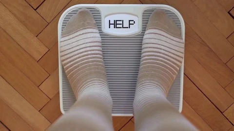 Person on the weight scale-HELP Stock Footage 80732187