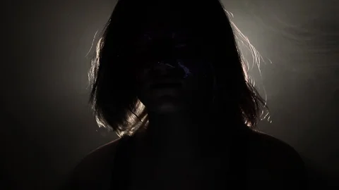 Person with weird face sits in the dark Stock Footage 121436067