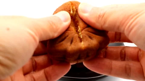 A person who cuts a maple leaf-shaped bun in half Stock Footage 335351477