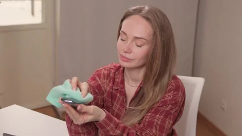 Person wipes black mouse using disinfectant spray and cloth. Closeup of lady Stock Footage 347878698