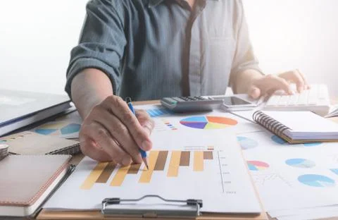 Person working and using a computer for financial and accounting concept. Stock Photos