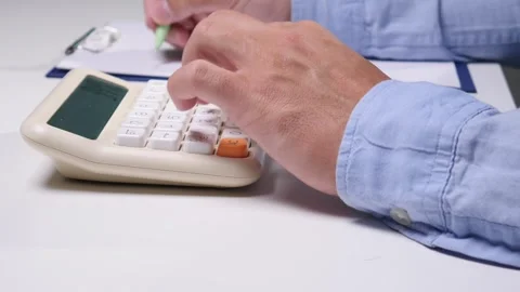 Person working on a budget. Using a calculator to manage finances and make 库存影片 342769858