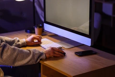 Person working on computer at desk with coffee and smartphone 스톡 사진