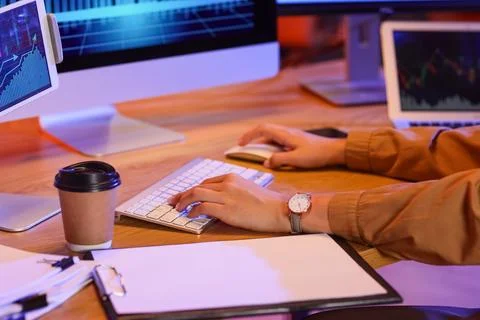 Person working on computer with multiple screens displaying financial graphs  스톡 사진