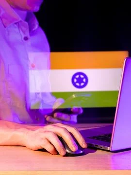Person working on computer with semi-transparent flag featuring blue symbol.. Stock Photos