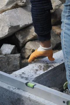 Person working on a construction project with stone blocks Stock Photos