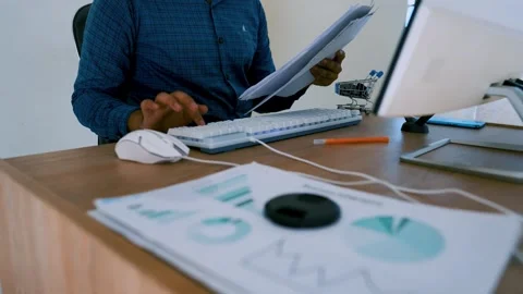 Person working at a desk with computer and documents Video stock 315981095