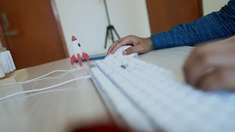 Person working at desk with computer and toy rocket video shot Stock Footage 318056580