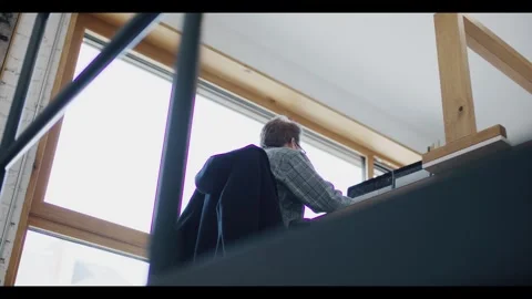 Person Working at Desk by Large Window, Modern Loft Office, Backlit Shot Stock Footage 340298888