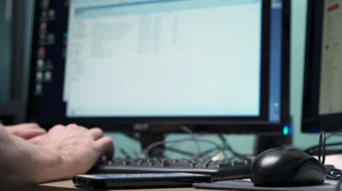 Person working at desktop computer and using smart phone 4k 库存影片 58772675