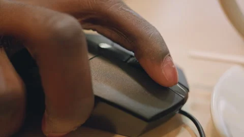 Person working diligently with wired mouse in warm office setting. Detailed view Stock Footage 333182865