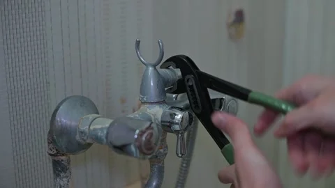 A person is working on fixing a pipe connection using hand tools in a home Stock Footage 339090507