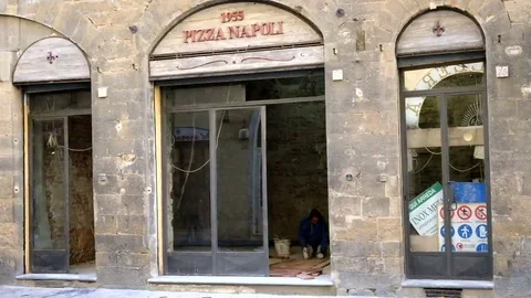 Person working inside a typical Pizza store. Florence, Italy Vidéo 69079148