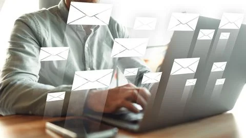 Person working on laptop while receiving many emails at a desk during daytime Foto stock