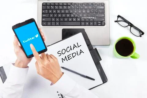 Person working in office while touching twitter logo Foto stock