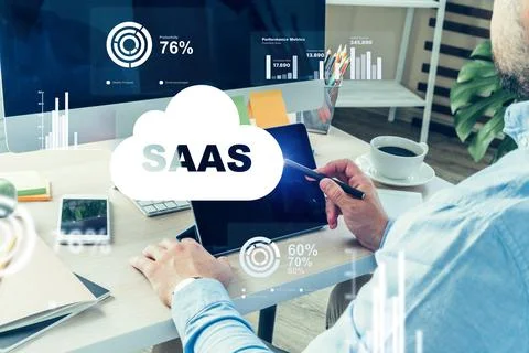 Person working with SaaS software on a tablet at a desk with a computer and Stock Photos