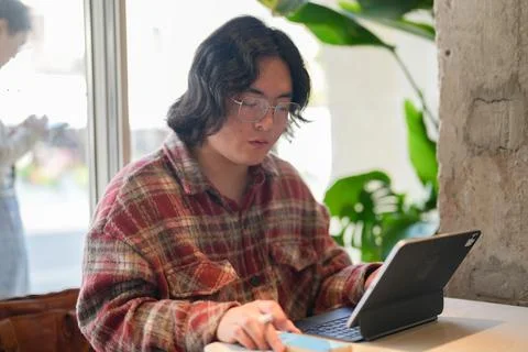 Person working with tablet by cafe window Stock Photos