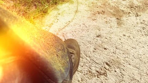 A person is working in the yard on a dirt path. Grass clippings are visible o Stock Photos