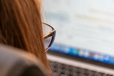Person Works on a Computer in an Indoor Setting With Natural Light Coming T.. Stock Photos