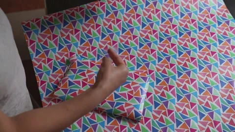 Person Wrapping a Box with Vibrant Patterned Paper Stock Footage 316836679