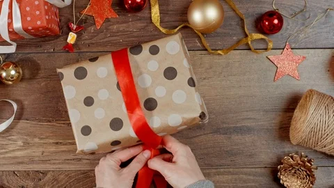 Person wrapping present with paper. Packaging wrapped gift box with ribbon. Stock Footage 117166070