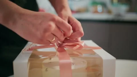 Person wraps a present with a pink bow Stock Footage 336053095