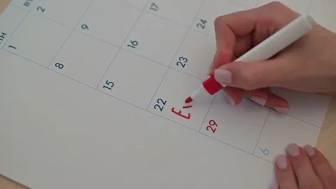 A person writes on a calendar using colored markers to highlight important dates Stock Footage 337556452