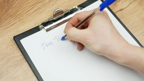Person writes love note to Valentine on paper, close up view Stock Footage 309568512