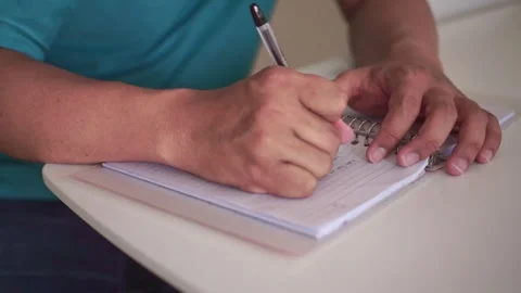 Person writes notes by hand, marks an error with a cross, then tears the paper Stock Footage 340322422