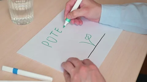 A person writes the word potential in clear letters on a piece of paper. The 스톡 동영상 337558449