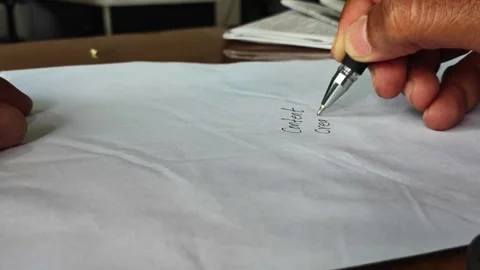 Person writing content creation in 2026 with a pen on paper Stock Footage 345549911