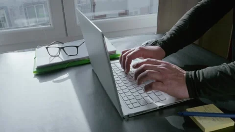 Person writing a note on a sticky pad at home office desk Stock Footage 337350276