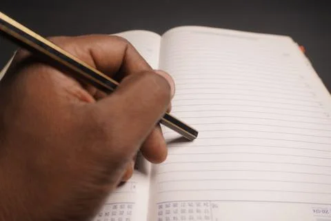 A person writing on a notebook, capturing thoughts or ideas Stock-Fotos