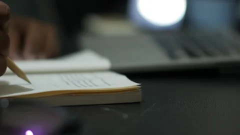 Person Writing in Notebook with Laptop in Background Stock Footage 345102082